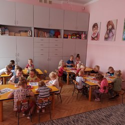 dzieci przy stolikach kolorują obrazek misia.jpg