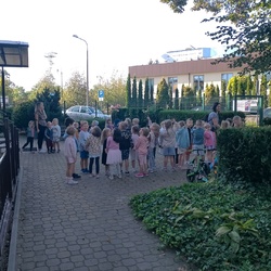 grupa dzieci z paniami przed budynkiem przedszkola.jpg