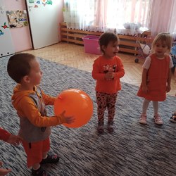 chłopiec trzyma pomarańczowy balon.jpg