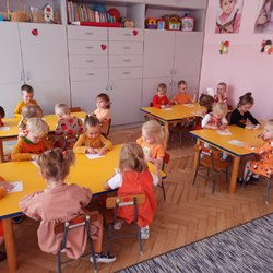 dzieci przy stolikach kolorują obrazek dyni.jpg