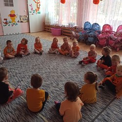 przedszkolaki siedzą w kole na dywanie.jpg