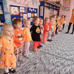 przedszkolaki w rzędzie w pomarańczowych strojach.jpg