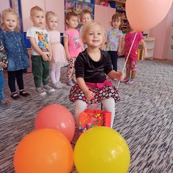 dziewczynka z balonami za nią przedszkolaki.jpg