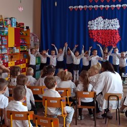 przedszkolaki z uniesionymi rękami śpiewają.jpg