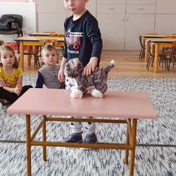 chłopiec z kotkiem zabawką na stoliku.jpg