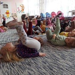 przedszkolaki leżą na dywanie z nogami do góry.jpg