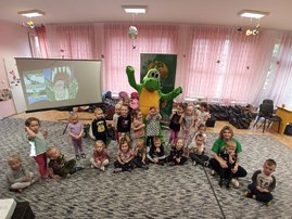grupa przedszkolaków z maskotką dinozaurem.jpg